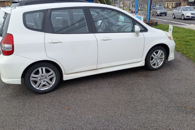 Side profile of a white 2007 Honda Fit