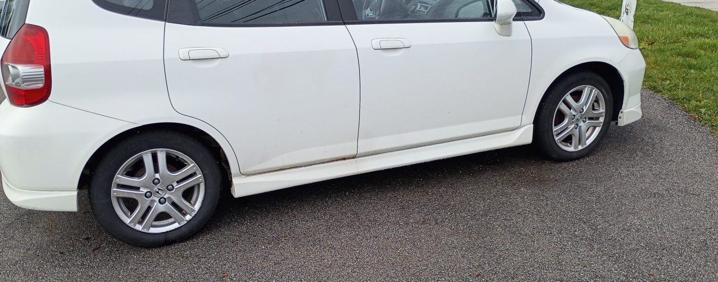 Side profile of a white 2007 Honda Fit